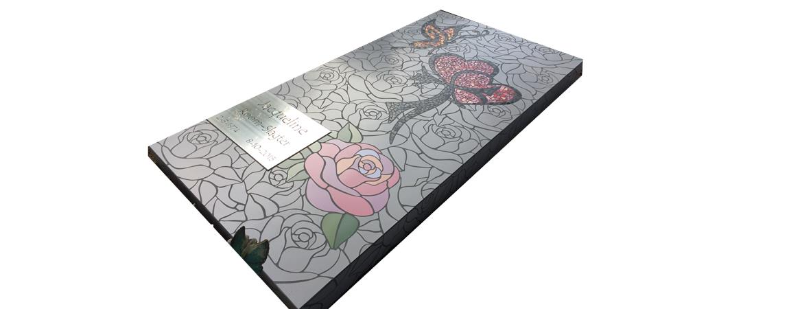 Grafmonument met gesneden rozen, grijze achtergrond en 1 x bloem in pastel kleur tinten